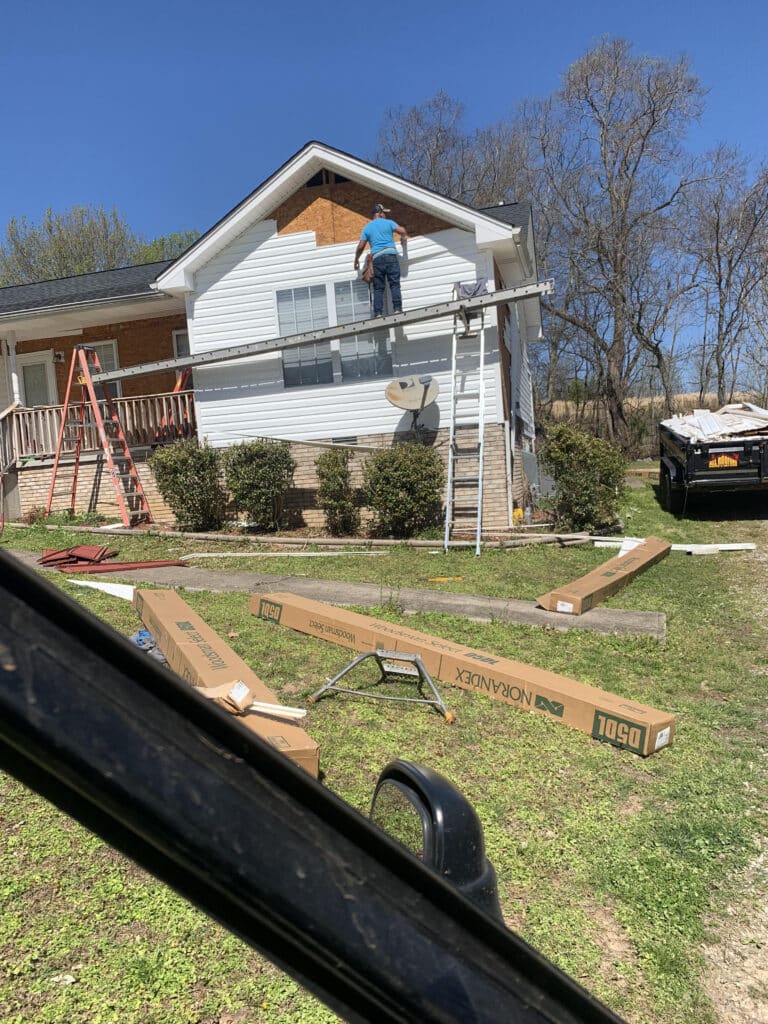 man replacing house siding